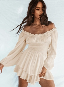 Detailed close-up of apricot off-shoulder romper with Swiss dot fabric and smocked waist