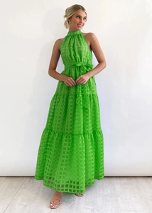 Detail of green halter neck dress featuring layered tier skirt and plaid texture