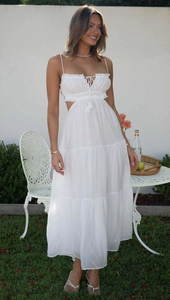 Detail of white sleeveless maxi dress with waist cut-outs and layered ruffle skirt design
