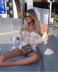 Détail du haut de plage en maille blanche et sac bandoulière argenté à clous