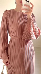 Detail of pleated long dress in dusty pink featuring flared sleeves and waist belt