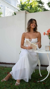 Detail view of white layered maxi dress featuring spaghetti straps and pleated neckline