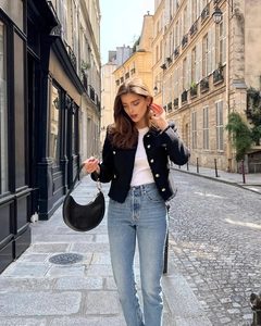 Classic black tweed jacket styled with gold buttons and light blue jeans on street
