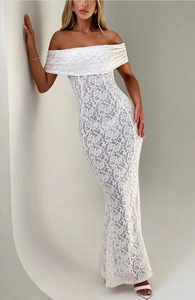 Détail du tissu en dentelle florale blanche et col bateau sur une robe longue ajustée