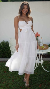 Close-up of a white tiered sleeveless maxi dress with waist cut-outs and drawstring tassels