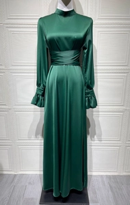 Détail de la robe en satin vert foncé montrant les plis à la taille et les volants
