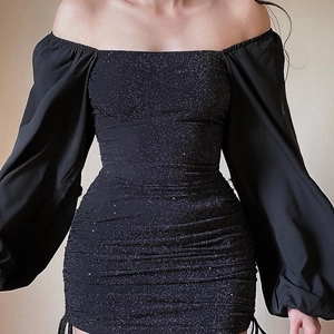 Detail of black glitter fabric with pleated ruffles and puffed sleeves on slim fit dress
