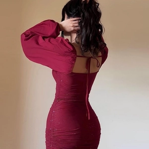 Detail of burgundy ruched dress featuring open back design with tie-up ribbons and glitter fabric