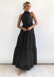 Detail of black halter maxi dress showing mesh texture and tiered pleated skirt design