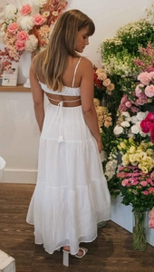 Detail of white tiered maxi dress featuring an elegant backless design with tie-up straps