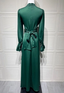 Détails de la robe en satin vert foncé avec poignets à volants et boutons argentés