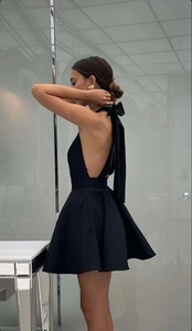 Détail de la robe mini dos nu élégante avec un grand nœud sur le col licou en noir