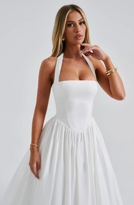 Detail of white halter-neck cocktail dress showing cinched waist and pleated skirt