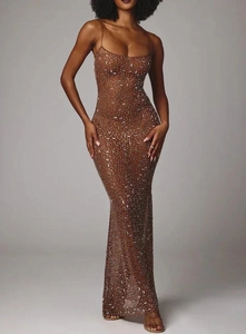 Close-up of sparkling silver sequins on brown mesh fabric of a sheer mermaid dress