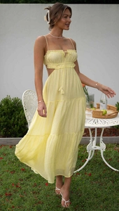 Detail of light yellow sleeveless sundress with waist cut-outs and tiered skirt layers