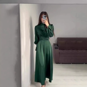 Détail de la robe en satin vert émeraude avec col montant et taille cintrée élégante