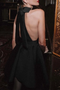 Détail d'une robe dos nu élégante avec grand nœud papillon et coupe trapèze noire classique