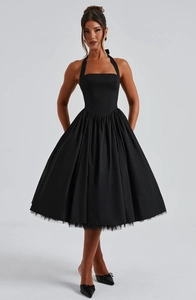 Detail of elegant black halter dress featuring a cinched waist and pleated skirt