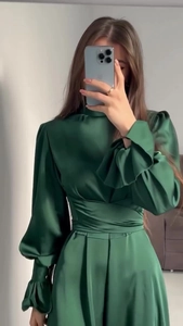 Détail de la robe en satin vert émeraude avec col montant et taille plissée