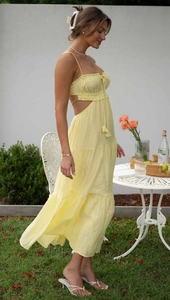Detail of yellow sleeveless maxi dress with waist cut-outs and tiered ruffle skirt layers