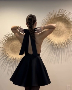 Détail du dos d'une robe licou noire avec un grand nœud papillon et dos nu sexy