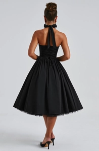 Detail of elegant black halter dress featuring a lace-up back design and a chic bow tie