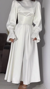Détail de robe élégante en satin blanc avec poignets à volants et coupe de taille ajustée