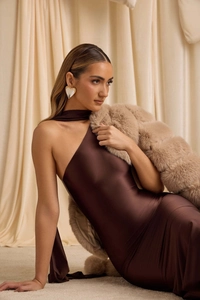 Close-up of elegant dark brown satin backless gown with single shoulder halter design
