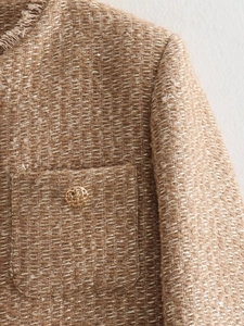 Close-up of khaki tweed jacket featuring golden hollow buttons and textured fringe edges