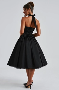 Detail of the back smocking and elegant mesh tulle hem on this black halter dress