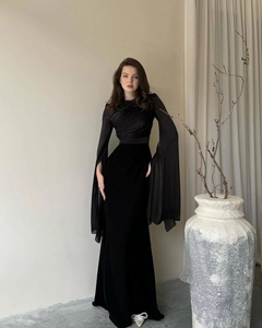 Close-up of elegant black evening dress with velvet bodice and sheer chiffon batwing sleeves