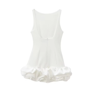 Detail of white backless dress featuring a voluminous tiered ruffle hem and satin finish