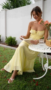 Detail of light yellow tiered maxi dress with ruffle neckline and waist cut-outs