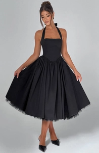 Detail of elegant black halter dress featuring a layered tulle hem and voluminous skirt