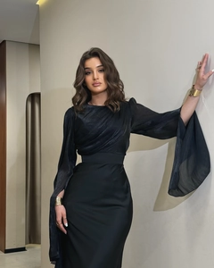 Detailed view of elegant black slim-fit dress with ruched bodice and sheer batwing sleeves