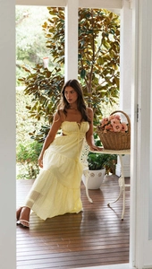 Detail of light yellow maxi dress with tiered skirt and side cutouts for summer vacation