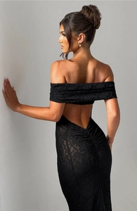 Détail d'une robe en dentelle noire dos nu avec coupe moulante et broderies florales
