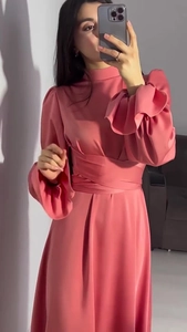 Détail de la robe en satin rose avec manches lanternes et design noué à la taille