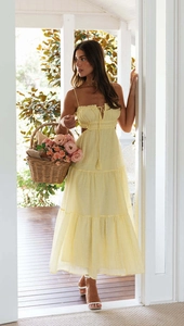 Detail view of light yellow tiered maxi dress featuring side cut-outs and ruffled bodice