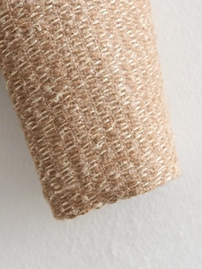 Macro detail of khaki tweed fabric with metallic glitter yarn and woven texture on jacket