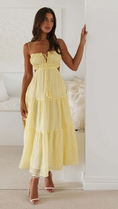 Detail of pale yellow sundress featuring waist cut-outs and layered tiered maxi skirt