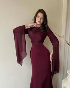 Close-up of elegant burgundy dress featuring diagonal pleats and long fringe slit sleeves