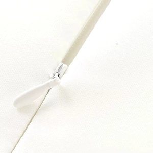 Detailed macro view of the seamless invisible zipper on a white backless summer dress
