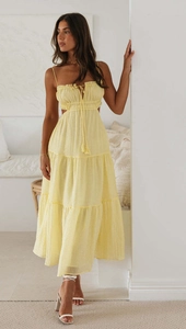 Close-up of yellow sundress with ruffle bust, side cut-outs and tiered maxi skirt