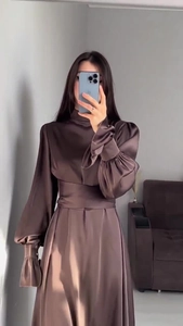 Détail d'une robe en satin marron café avec manches bouffantes et taille cintrée élégante