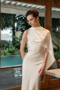 Détail de la robe en satin crème avec un drapé élégant sur une épaule et une texture brillante