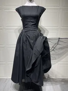 Detail of a black backless maxi dress featuring mesh fabric and a waist-cinched design