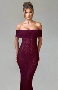 Détail de la dentelle florale rouge foncé sur une robe de soirée moulante à épaules nues