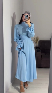 Détail d'une robe en satin bleu clair avec manches bouffantes et poignets volantés