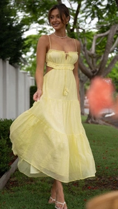 Detail of light yellow summer maxi dress featuring waist cut-outs and tiered skirt